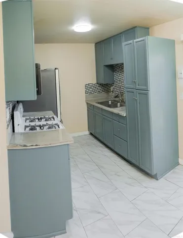 a kitchen with stainless steel appliances a sink stove and refrigerator