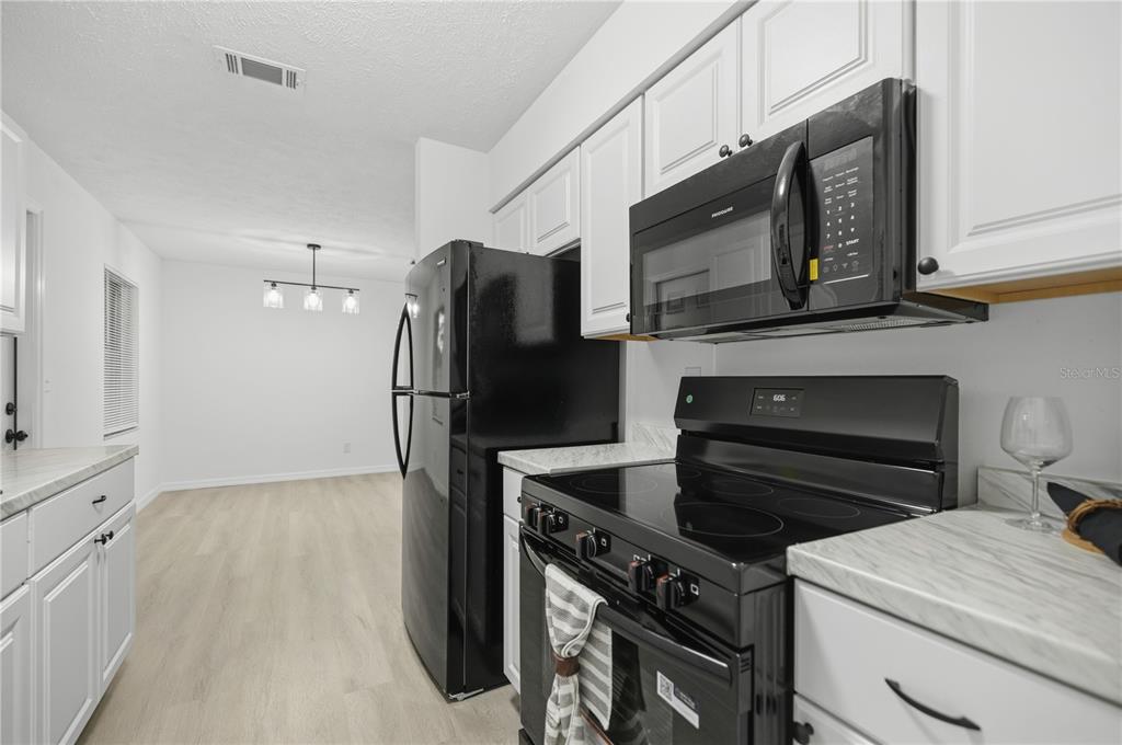 3753 Southeast 67th Place Ocala, FL 34480 - Photo 12 of 30 a kitchen with a refrigerator stove and microwave