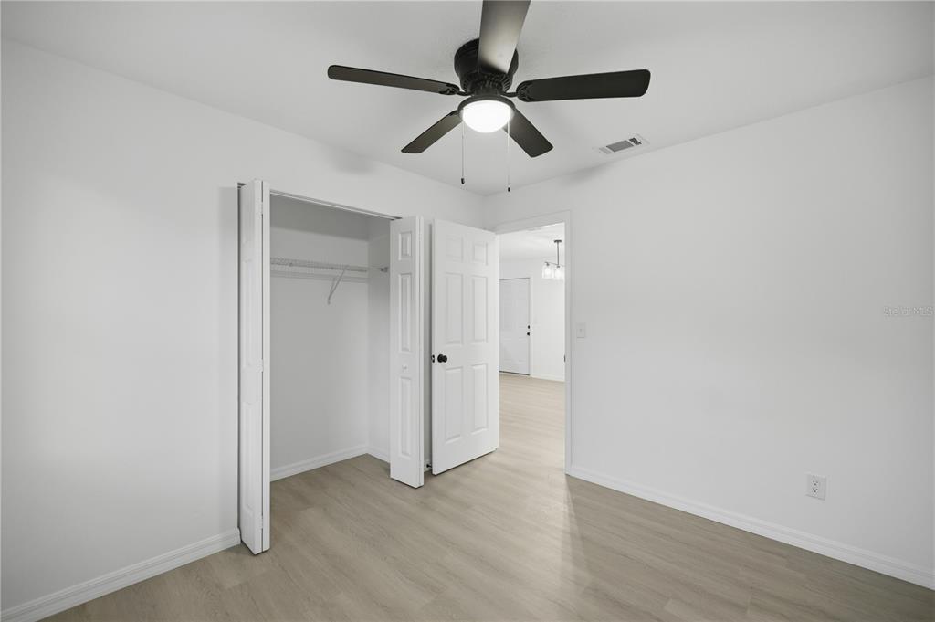 3753 Southeast 67th Place Ocala, FL 34480 - Photo 20 of 30 an empty room with wooden floor ceiling fan and window