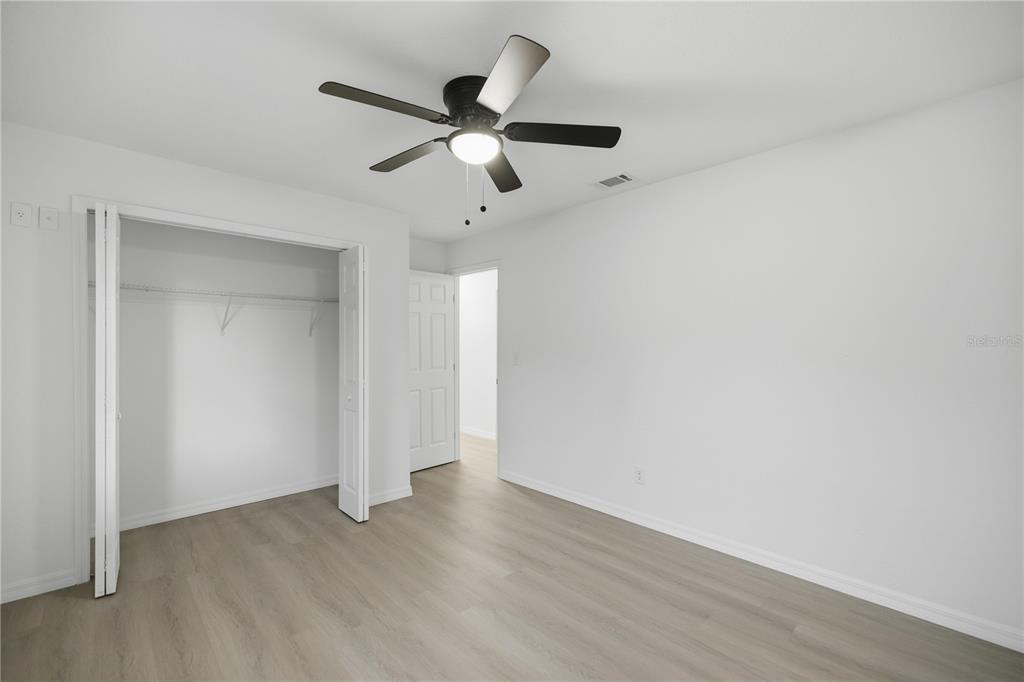 3753 Southeast 67th Place Ocala, FL 34480 - Photo 22 of 30 an empty room with wooden floor fan and windows