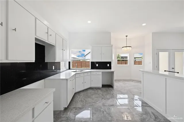 a large white kitchen with cabinets
