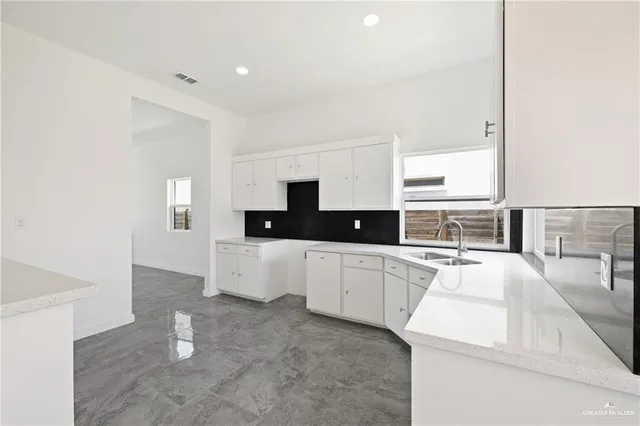 a large white kitchen with cabinets