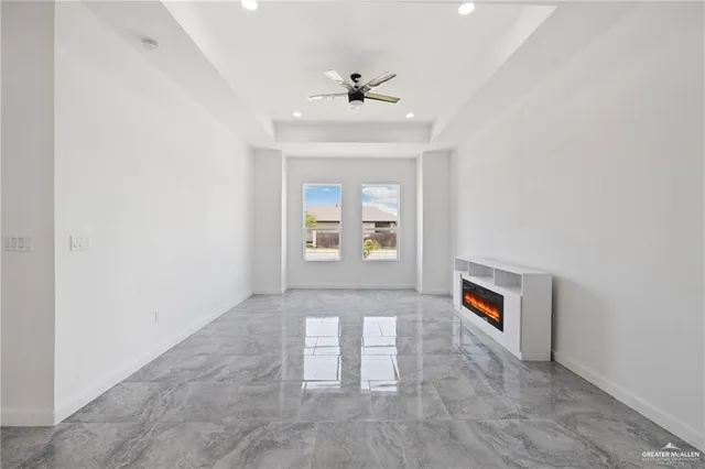 an empty room with windows and ceiling fan
