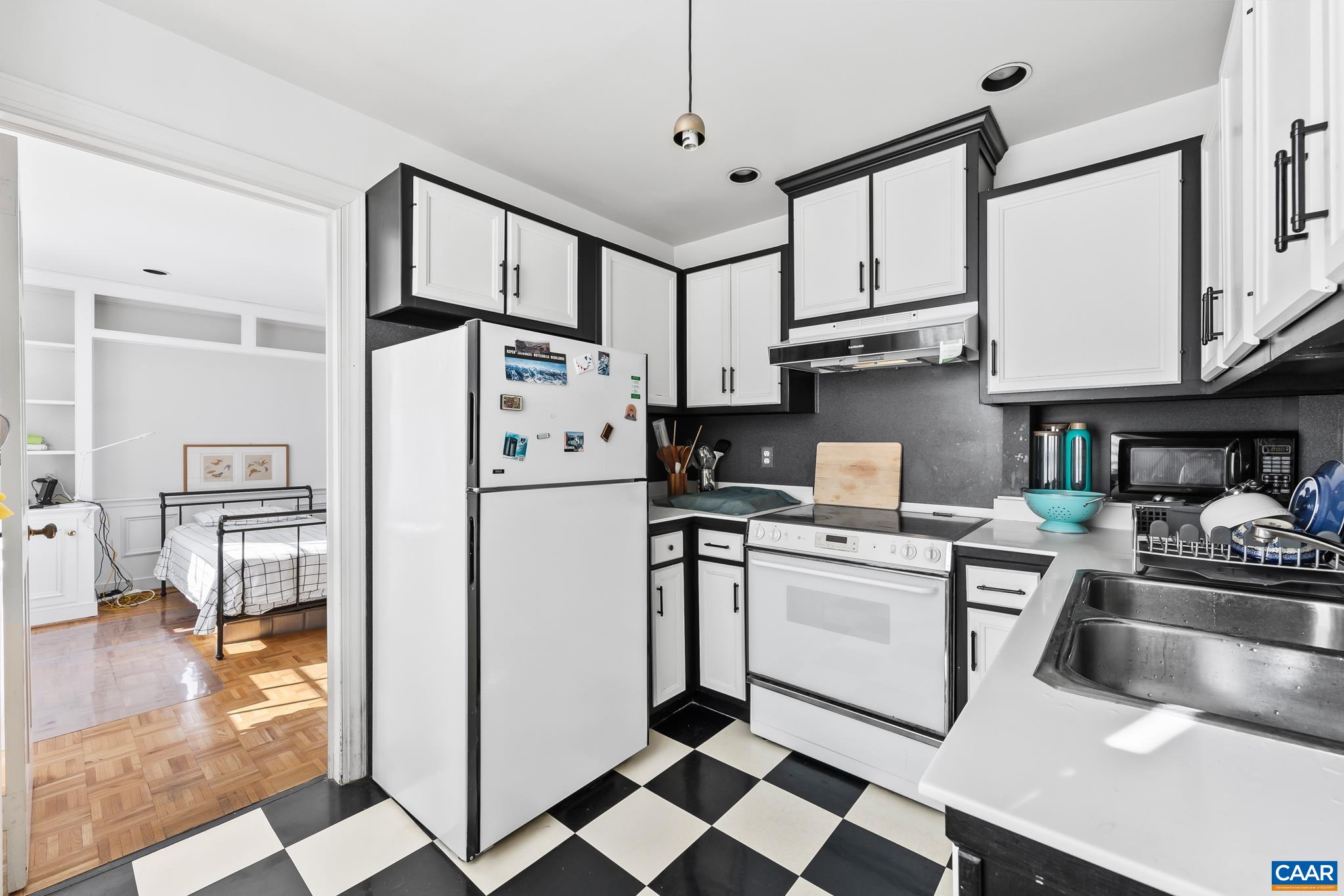 500 Court Square, Unit 505 Charlottesville, VA 22902 - Photo 13 of 16 a kitchen with stainless steel appliances granite countertop a refrigerator a stove and white cabinets with wooden floor
