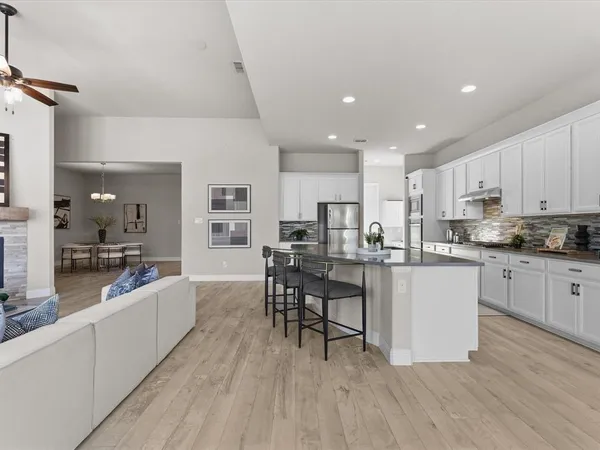 a large kitchen with stainless steel appliances kitchen island granite countertop a sink and cabinets