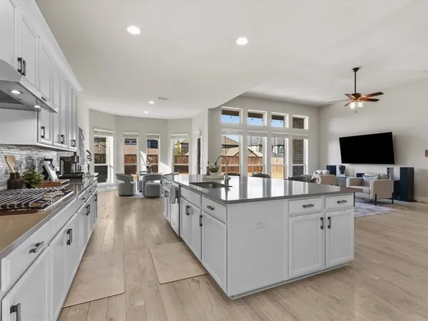 a kitchen with stainless steel appliances kitchen island granite countertop a sink refrigerator and cabinets