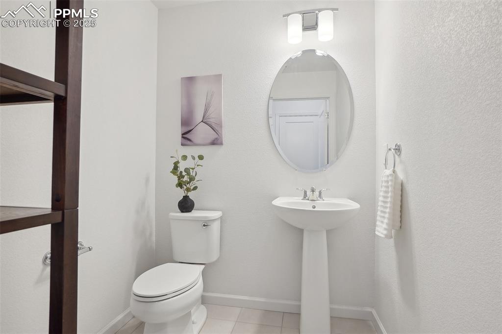 1743 Spring Water Point Colorado Springs, CO 80908 - Photo 16 of 35 a bathroom with a sink a toilet and a mirror