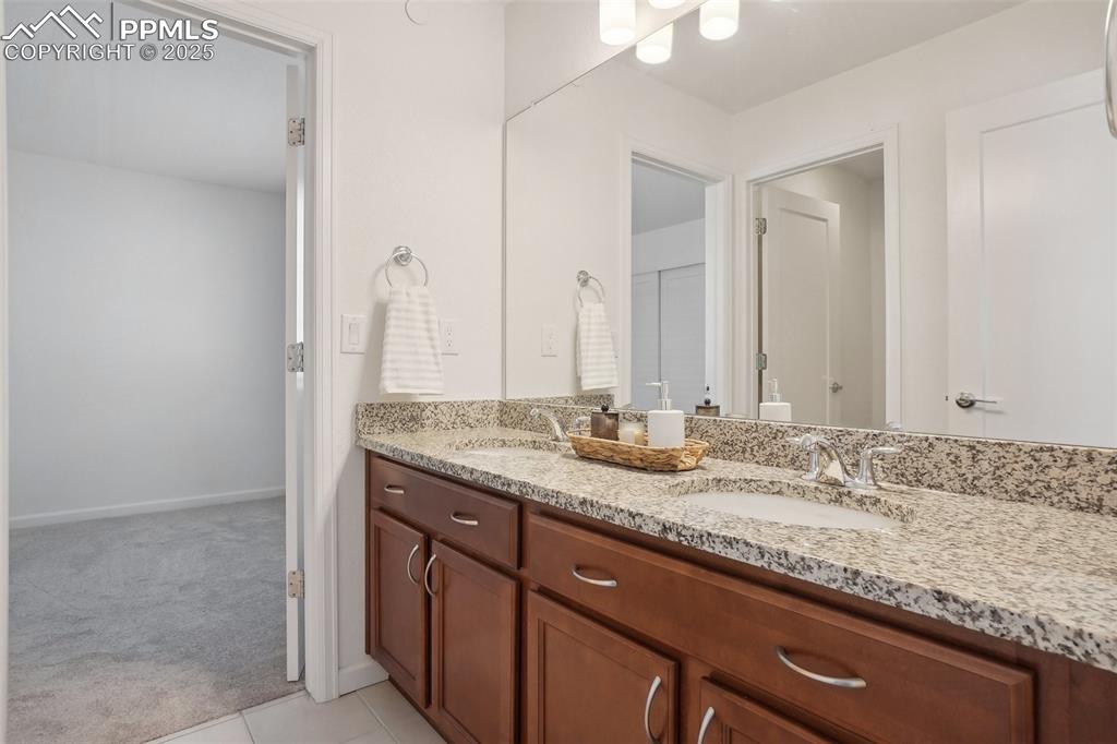 1743 Spring Water Point Colorado Springs, CO 80908 - Photo 31 of 35 a bathroom with a granite countertop sink and a mirror
