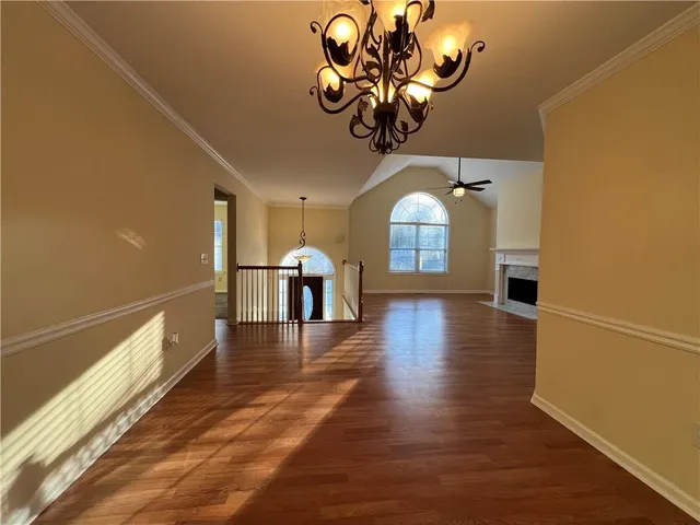 a view of a room with wooden floor and chandelier