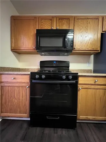 a kitchen with stainless steel appliances a stove a microwave a sink and cabinets
