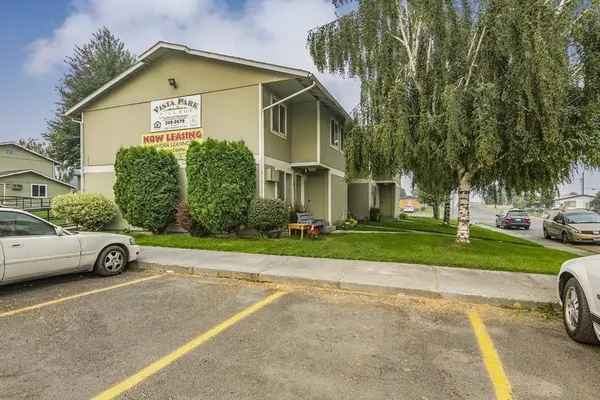 a view of a car parked in front of a house with a yard