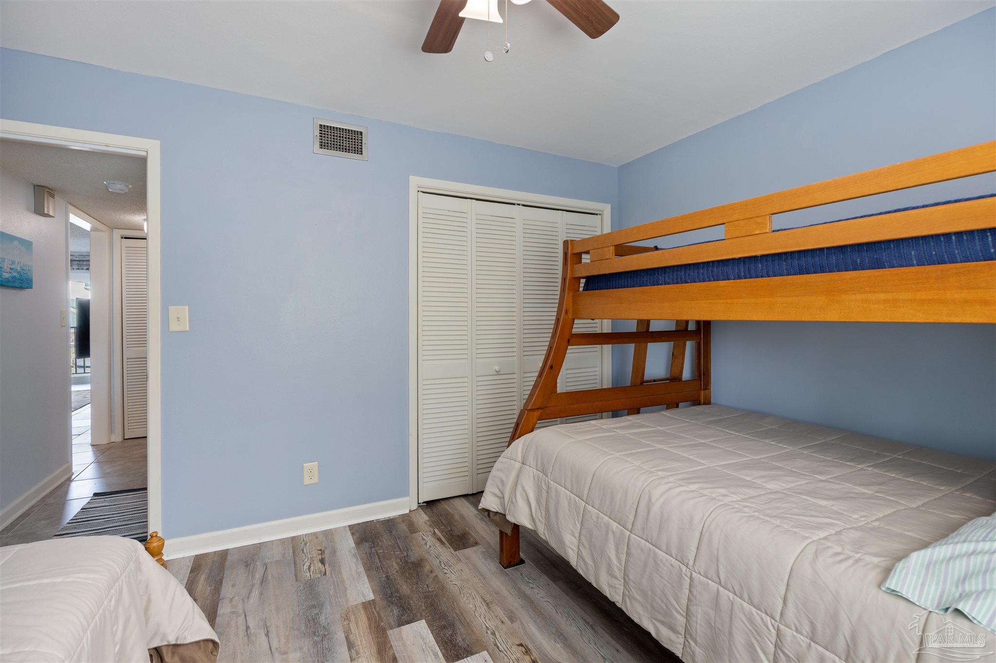 14100 River Road, Unit 228B Pensacola, FL 32507 - Photo 24 of 41 a bedroom with a bed and a chandelier