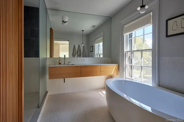 a view of bathroom with a tub and a window