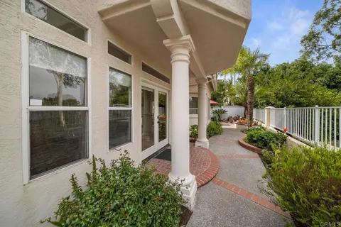 a view of a patio with furniture and table under an umbrella