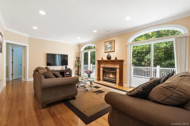a living room with furniture a fireplace and a floor to ceiling window