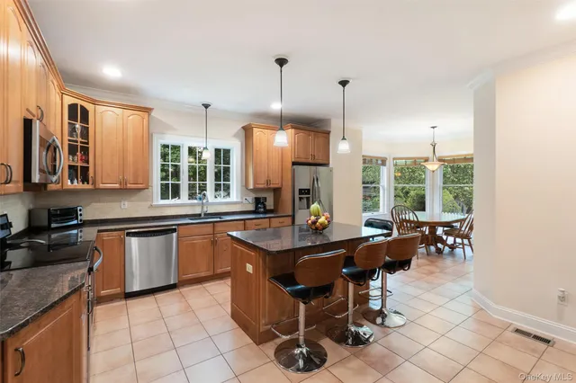a kitchen with stainless steel appliances granite countertop a stove a sink dishwasher and a wooden cabinets