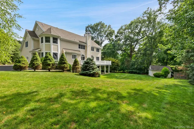 a front view of a house with a yard and trees