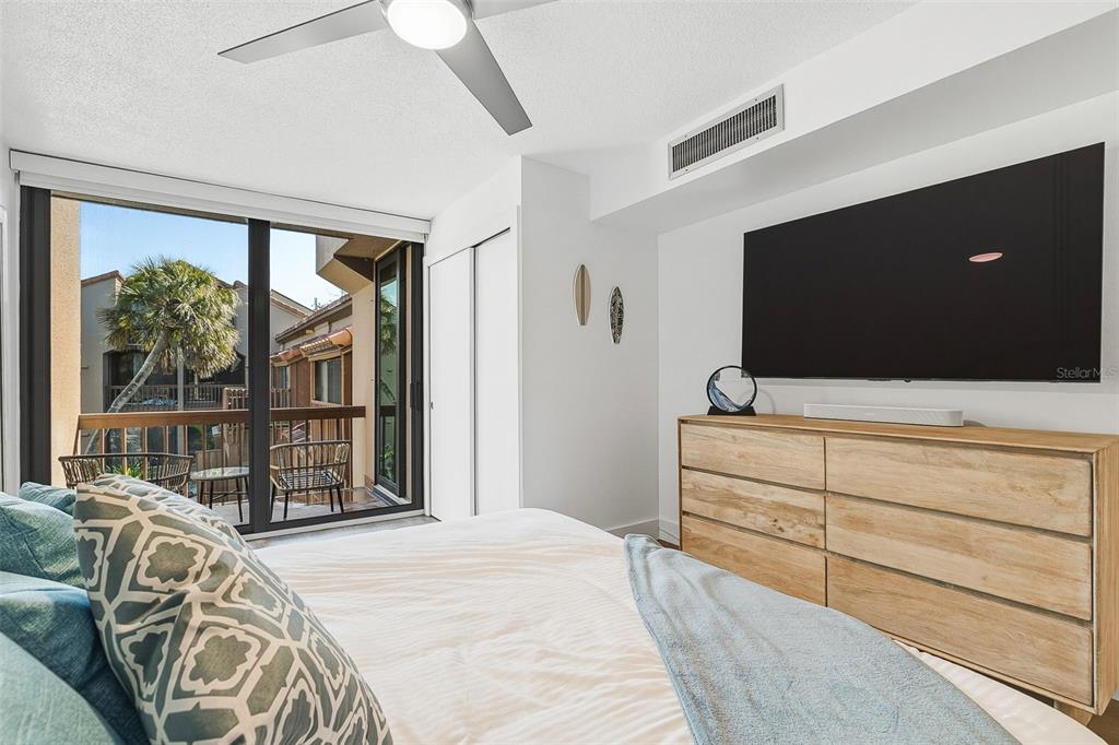 208 Pass Key Road, Unit 208 Sarasota, FL 34242 - Photo 13 of 29 a bedroom with a bed and a flat tv screen on dresser