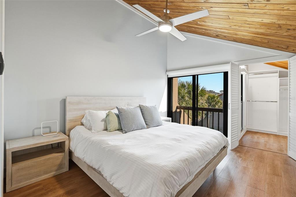 208 Pass Key Road, Unit 208 Sarasota, FL 34242 - Photo 17 of 29 a bedroom with a large bed and a chandelier