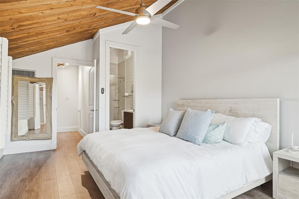 208 Pass Key Road, Unit 208 Sarasota, FL 34242 - Photo 20 of 29 a bedroom with a bed and a chandelier