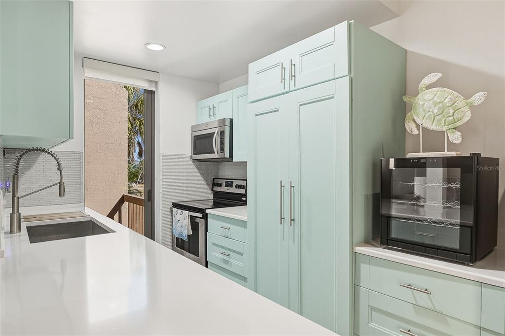 208 Pass Key Road, Unit 208 Sarasota, FL 34242 - Photo 9 of 29 a kitchen with stainless steel appliances a refrigerator stove and sink