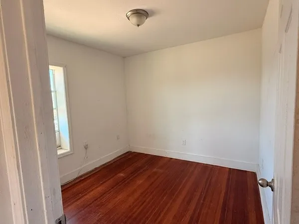 a view of a room with wooden floor and window