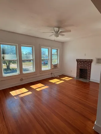 a view of empty room with window and wooden floor