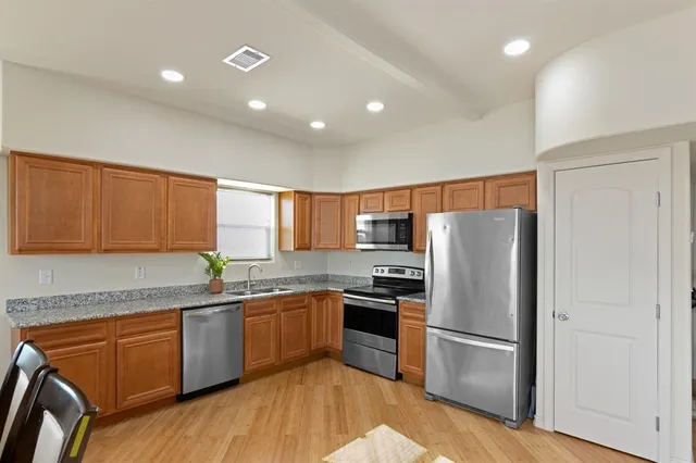 a kitchen with stainless steel appliances granite countertop a refrigerator sink and cabinets