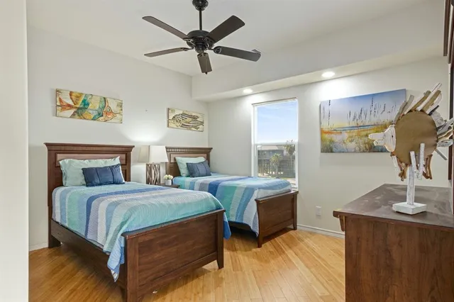a bedroom with a bed a dresser and potted plant