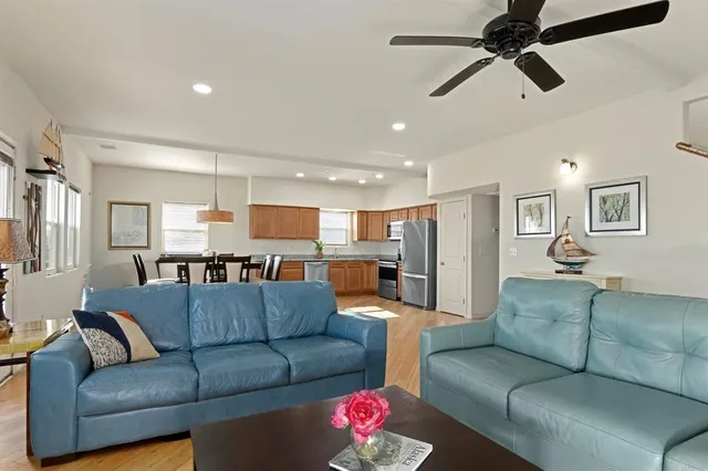 a living room with furniture kitchen view and a chandelier