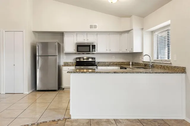 a kitchen with a refrigerator a stove a microwave and cabinets