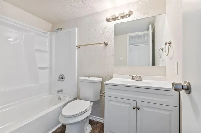 a bathroom with a sink toilet tub vanity and shower