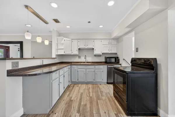 a kitchen with granite countertop a sink cabinets and stainless steel appliances