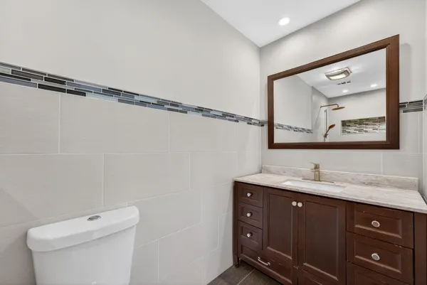 a bathroom with a granite countertop sink a toilet and a mirror