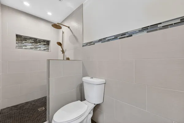 a white toilet sitting next to a shower curtain