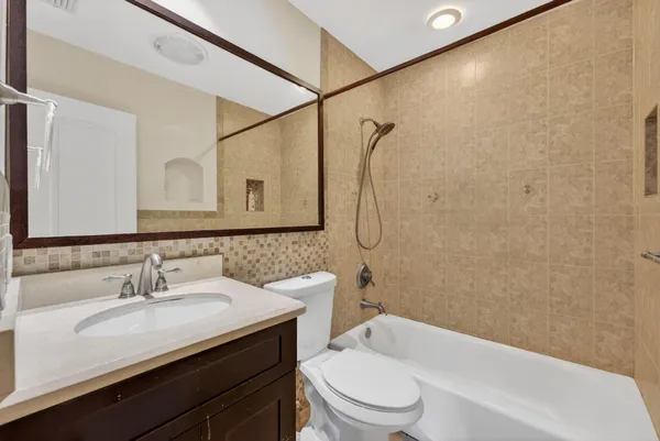 a bathroom with a granite countertop sink a toilet and shower