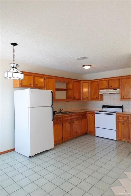 3401 North Inspiration Road, Unit 1 Mission, TX 78573 - Photo 3 of 9 a kitchen with stainless steel appliances granite countertop a stove a sink and a refrigerator