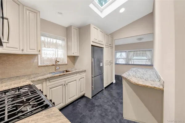 a kitchen with stainless steel appliances granite countertop a stove a sink and a refrigerator