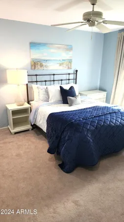 a bedroom with bed a couch and a ceiling fan