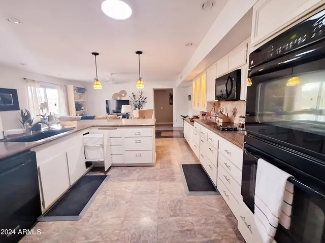 a kitchen with stainless steel appliances granite countertop a stove refrigerator and cabinets