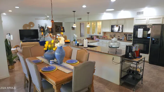a dining room filled a chandelier a glass table and chairs