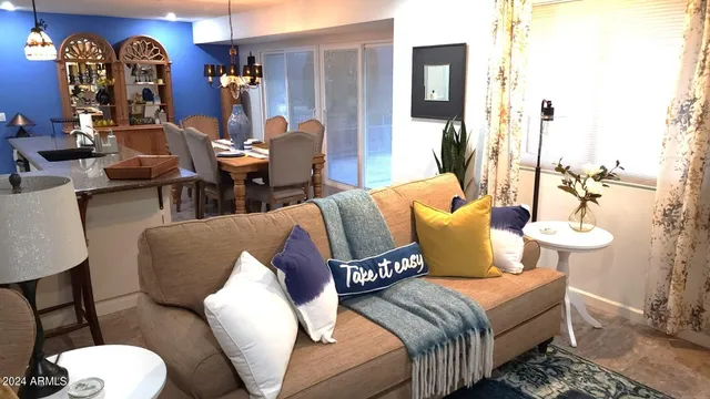 a living room with furniture a chandelier and a large window