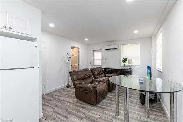 a living room with furniture and a refrigerator