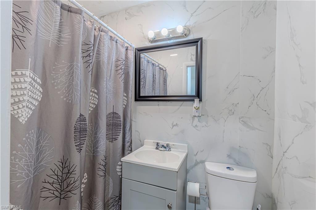 3132 Francis Avenue Naples, FL 34112 - Photo 21 of 23 a bathroom with a toilet sink and mirror
