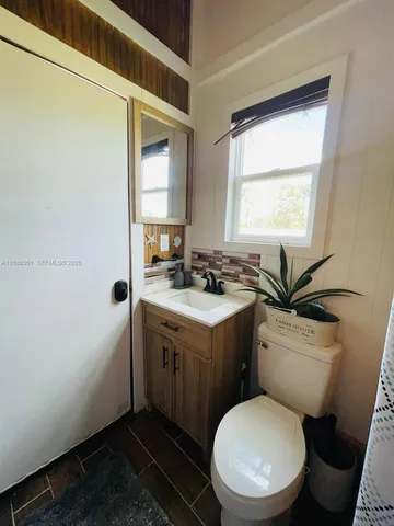 a bathroom with a toilet sink and mirror