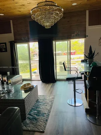 a living room with couches painting on the wall and a large window