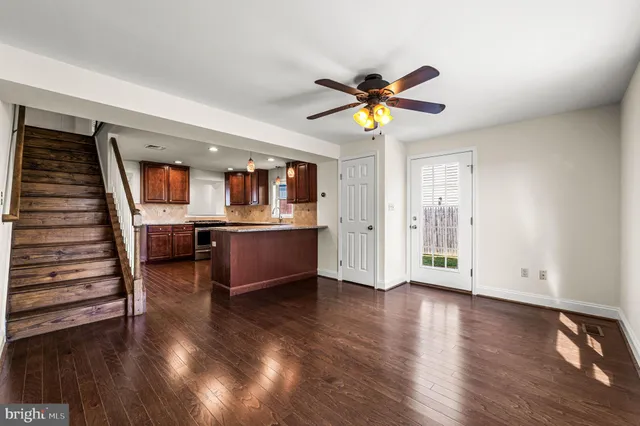 a view of a livingroom with wooden floor and a ceiling fan