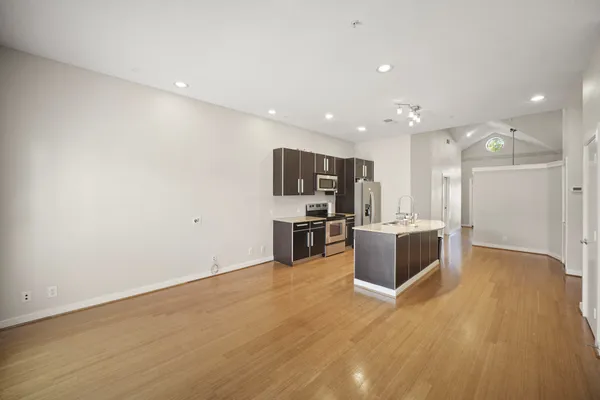 a view of kitchen with stainless steel appliances kitchen island wooden floor and window