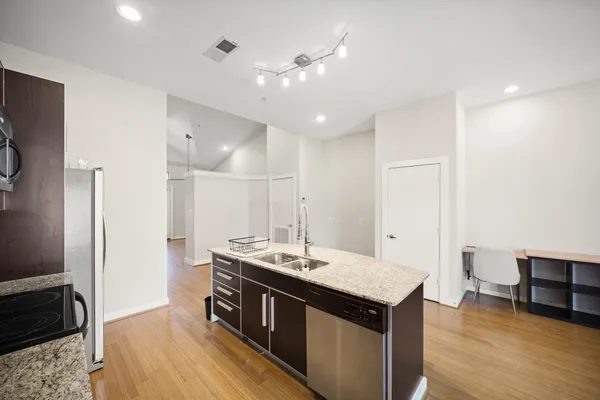 a kitchen with a stove a refrigerator and a sink