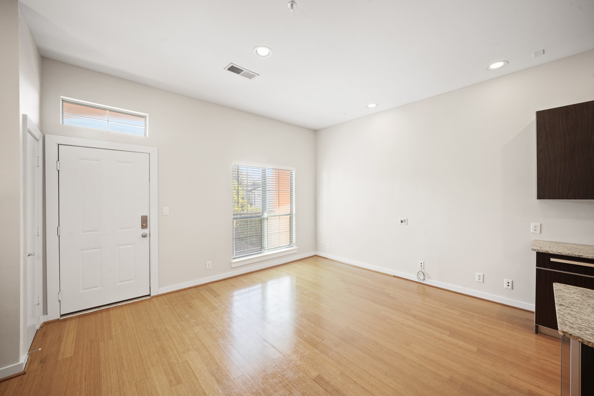 806 Jackson Hill Street, Unit 302 Houston, TX 77007 - Photo 9 of 26 a view of an empty room with wooden floor and a window